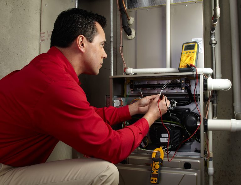 Technician testing a furnace unit during AC installation service in Roseburg, OR